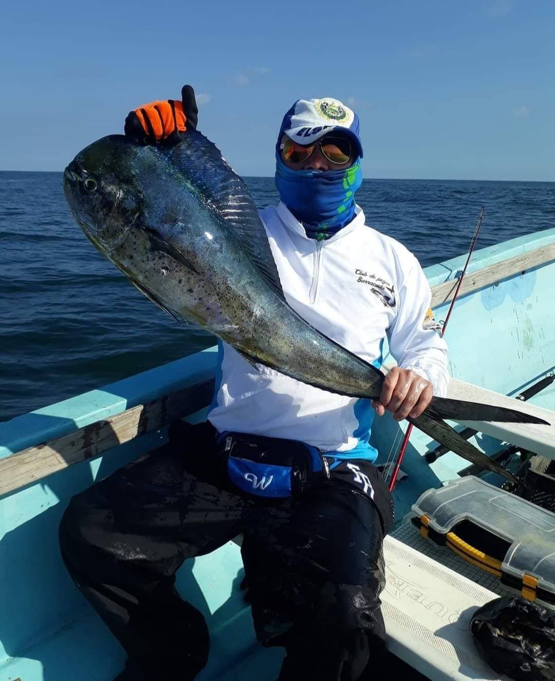 Dorado sostenido por la cola en alta mar
